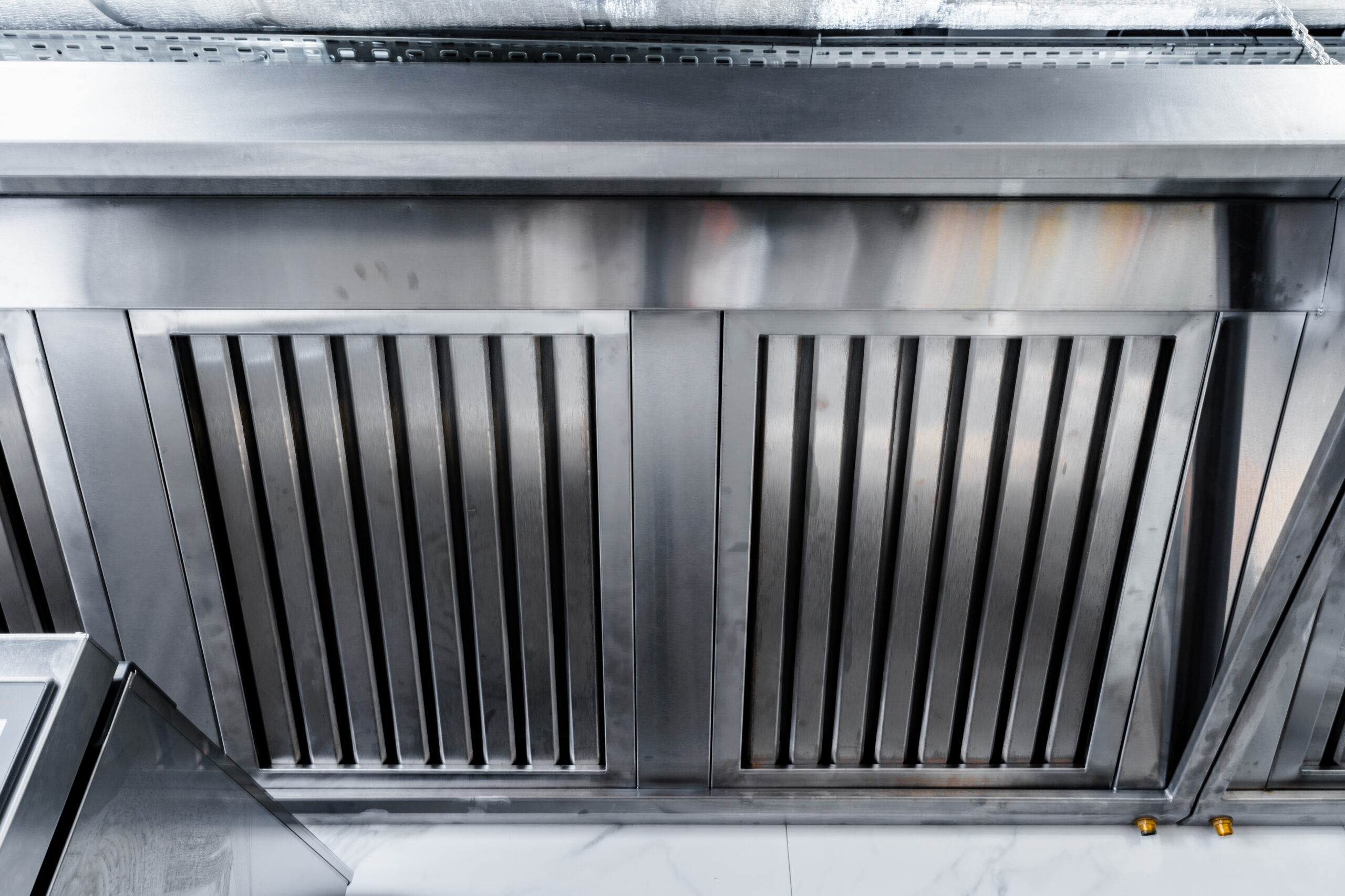New clean stainless steel hood in professional kitchen close up